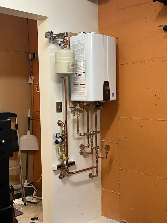 Plumbing technician inspecting water heater connections in Arab